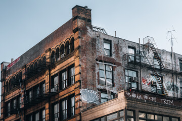 A building with a lot of graffiti on it. The building is old and has a lot of windows
