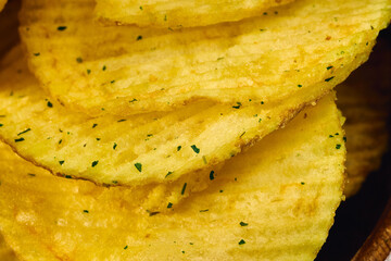 Golden potato chips are layered neatly, showcasing their ridged texture