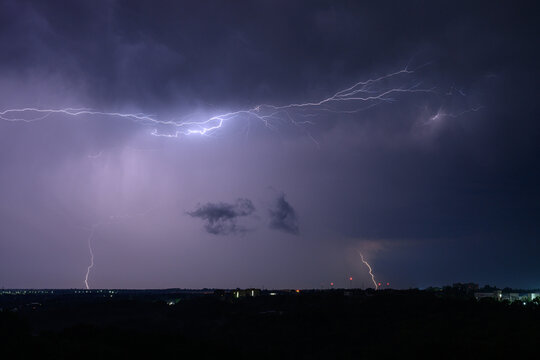 Horizontal lightning flashes across a purple night sky - Powered by Adobe