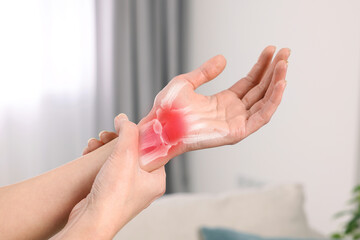 Arthritis. Woman suffering from wrist pain indoors, closeup. Illustration of joint inflammation on...