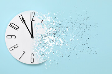Time running out. Clock dissolving on light blue background