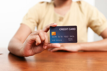 Hand holding credit card home office financial transaction indoor close-up view secure payment concept