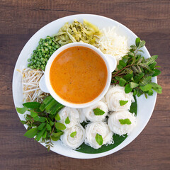 Khanom Jeen Namya Kati with fresh and pickled vegetables as side dishes