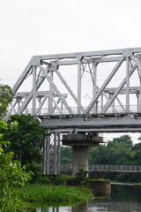 Fototapeta premium Steel Truss Railway Bridge Over River – Infrastructure in Natural Setting