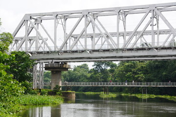 A railway bridge over a river, a pedestrian bridge also there in background