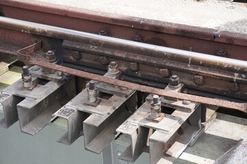 A close-up of a railway track, highlighting several key components on it