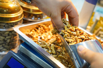 The nut seller is weighing walnuts
