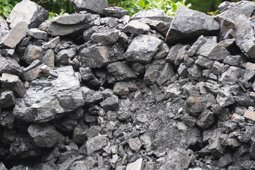 Pile of Gray Charcoal with Mixed Shapes and Rough Texture in Outdoor Natural Setting