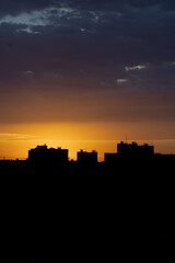 Orange sky. Morning in town. Panorama of the metropolis. Silhouette of houses. Peaceful life. Calm sky. Color gradient in nature. Heavenly landscape. Urban skyline.