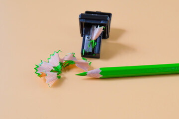 Green pencil tip shavings from sharpener on background .
