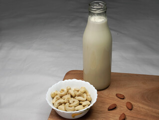Various type vegan milk almond, coconut, cashew, on white background. Vegan plant based milk and ingredients, top view. Healthy food concept.