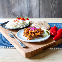 Home cooked beef chilli dish with rice, pitta bread and tomatoes and red onions