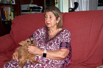 A heartwarming scene with a grandmother and her red-haired dog demonstrating unity and affection in the living room of a family home.