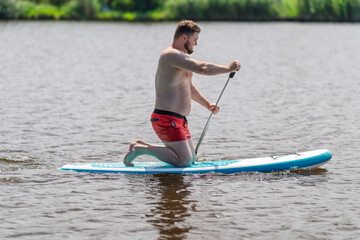 Young man using a SUP board.
