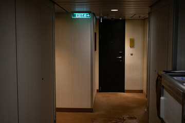 modern hallway interior with room door and emergency exit indicator