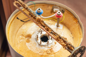 Corrosion and mineral deposits on the heating element of an electric boiler. Boiler maintenance and repair