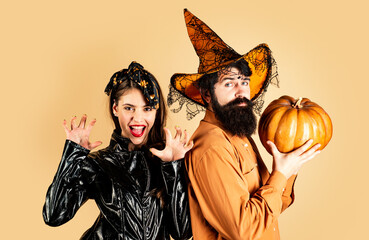 Happy couple in Halloween costume. Halloween couple with pumpkin and Halloween makeup. Man and...