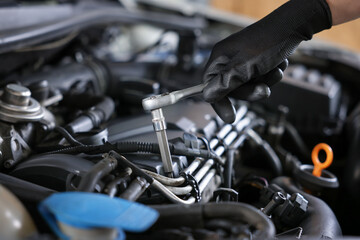 Auto parts. Professional mechanic with torque wrench fixing car indoors, closeup