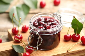 Tasty cherry jam and fresh fruits on wooden table, closeup