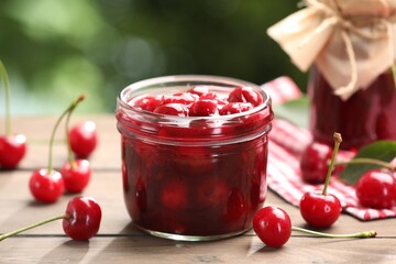 Tasty cherry jam and fresh fruits on wooden table against blurred background, closeup