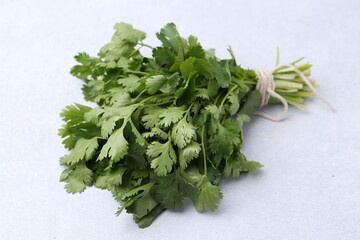Bunch of fresh aromatic cilantro on white table, closeup