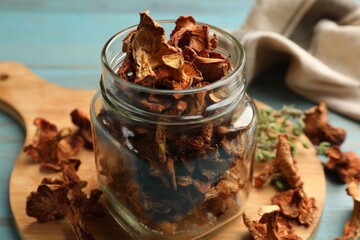 Dried chanterelle mushrooms with thyme on blue wooden table, closeup