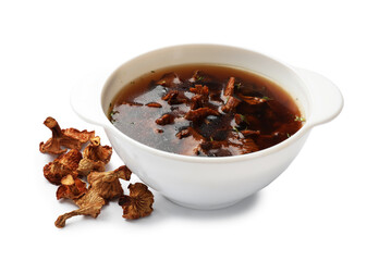 Tasty soup in bowl and dry chanterelle mushrooms isolated on white