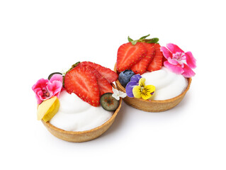 Sweet tartlets with berries and flowers isolated on white. Delicious dessert