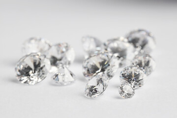 Many shiny diamonds on light background, closeup