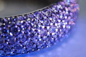 Ring with beautiful shiny diamonds on light background, macro view. Color toned