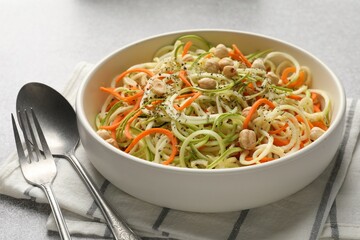 Tasty vegetable noodles with chickpeas served on grey table, closeup. Vegetarian dish