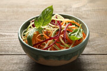 Tasty vegetable noodles on wooden table, closeup