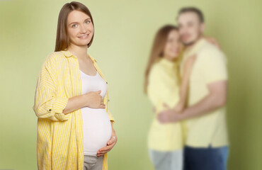 Surrogate mother and intended parents against olive color background, selective focus