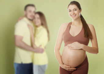 Surrogate mother and intended parents against olive color background, selective focus
