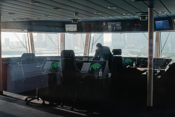 modern ship navigation bridge with captain overlooking the urban landscape