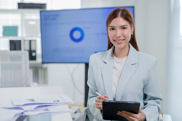 Young professional business woman smiling at camera with digital tablet in modern luxury office...