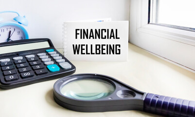 A text about financial well-being written in a notebook on a windowsill with a clock and a magnifying glass