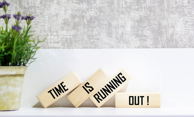 Wooden blocks with the text TIME IS RUNNING OUT on a beautiful background