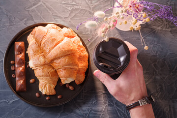 Guest holding coffee and croissants. Coffee with croissants and chocolate. Decorations on the...