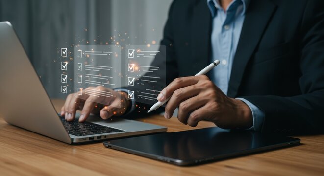 Business professional multitasking with laptop and tablet. Digital task management with checklists. Modern tech-savvy workspace.