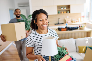 Young black couple moving into a new modern house, carrying boxes and arriving home together....