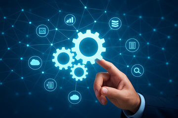 Fototapeta premium Businessman’s hand pressing cog wheels against a blue background, symbolizing teamwork and innovation in business