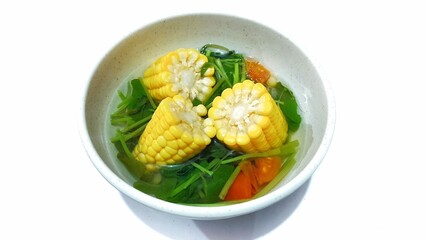 Spinach Clear Soup with Corns. Sayur bening bayam jagung served in white bowl, Indonesian popular food 