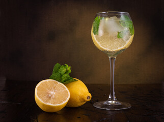 Refreshing summer drink in a glass. Cocktail. Lemon and mint in a glass. Vintage still life.
