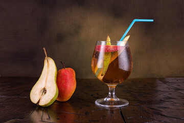 Fresh fruit drink. Pear lemonade. Pear drink in a glass. Glass glass with a straw. Pear slices near the glass.