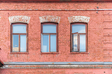 Three windows of the old mansion 19 century with brown bricks wall