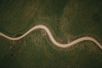 Serpentine path meandering through untouched natural hills in a tranquil farmland setting