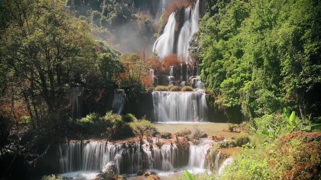 A beautiful waterfall cascades through a lush green forest