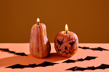 Halloween-style candles on a orange background. Festive decor.