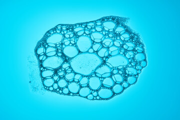 Beautiful foam texture in blue tones. Bubbles of detergent or bubble bath.